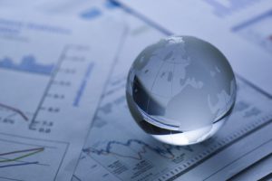 Glass globe on stock market chart . shot with very shallow depth of field.blue tone